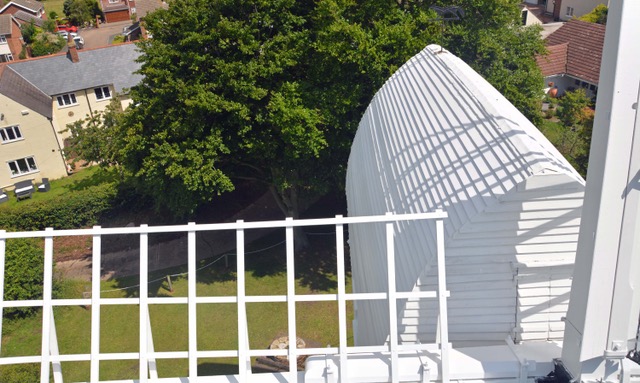 Overhead shot of bocking windmill showing the rear of the structure and some trees and houses in the background