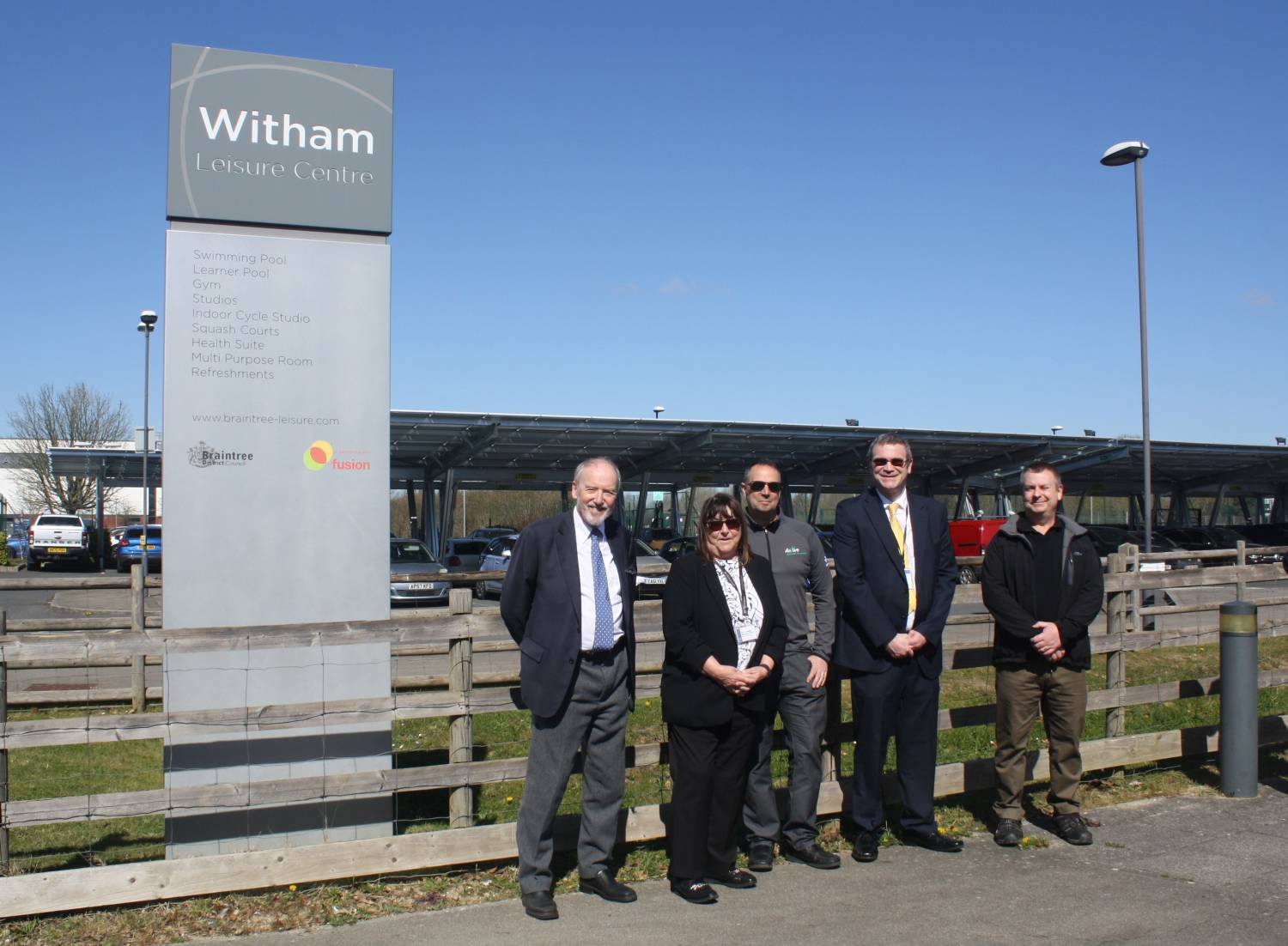 A line up of the councillors quoted and BDC staff next to the Witham Leisure Centre sign, in front of the car park solar canopy.