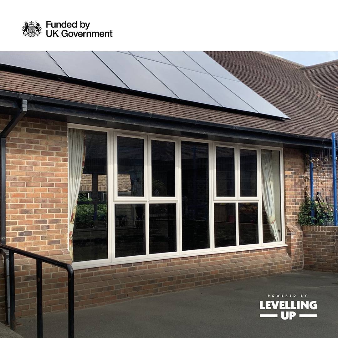 A photo of a community hall with energy efficient windows and solar panels on the roof.