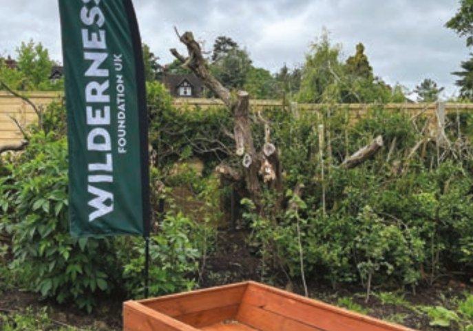 photo of wilderness foundation banner with trimmed trees and bushes in the background