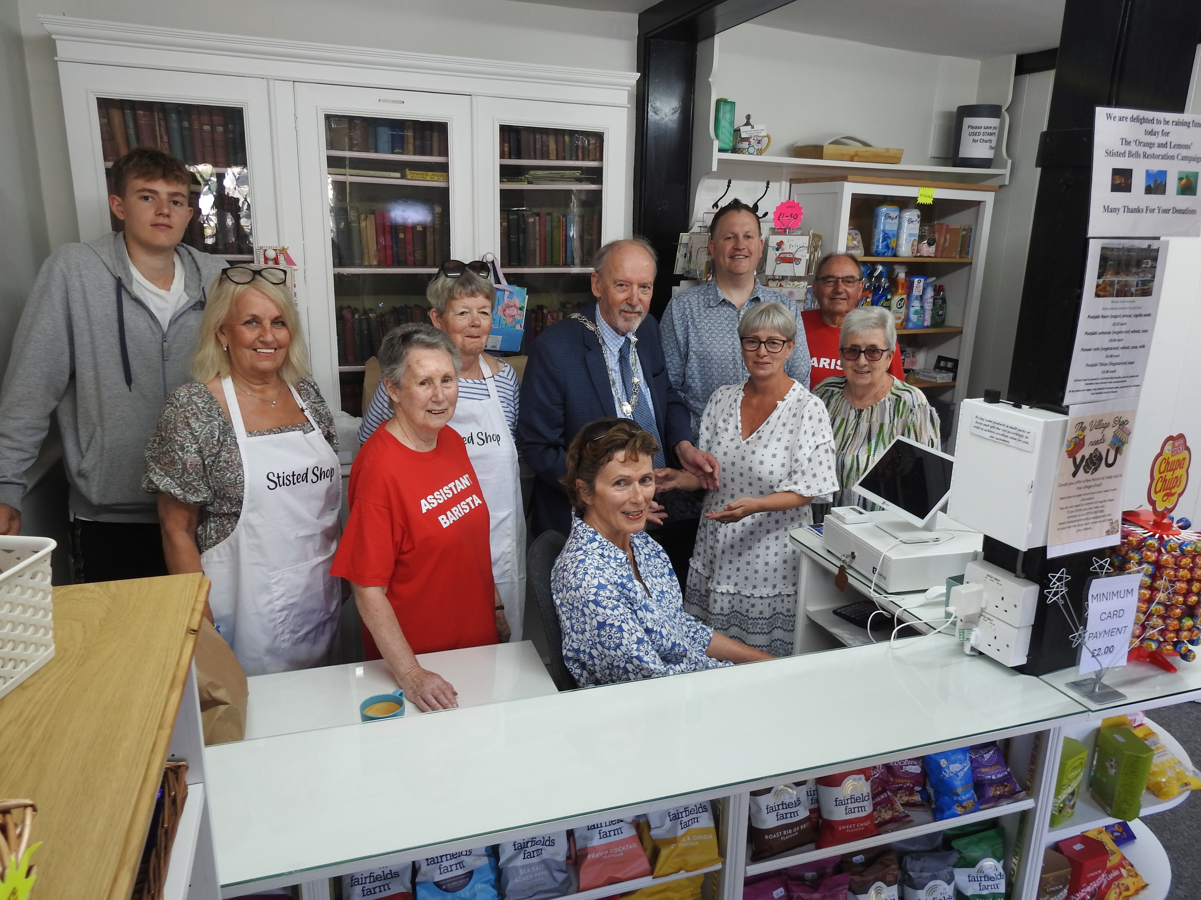 Cllr Richard van Dulken (Chairman of Braintree District Council) together with Cllr Justin Wrench (Cabinet Member for Economic Growth) presenting a plaque to the volunteers from the community shop.