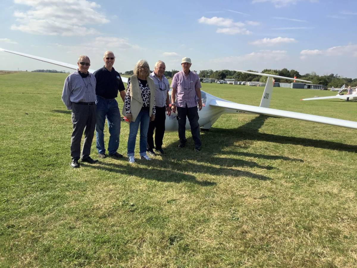 An image of people standing by a glider