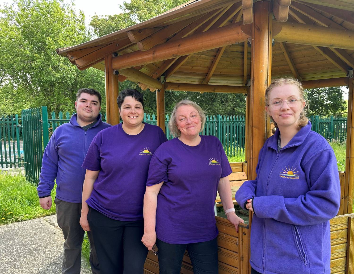 Four people from Happy Hill charity smiling at the camera