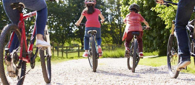 two adults and two kids riding their bikes in the country side