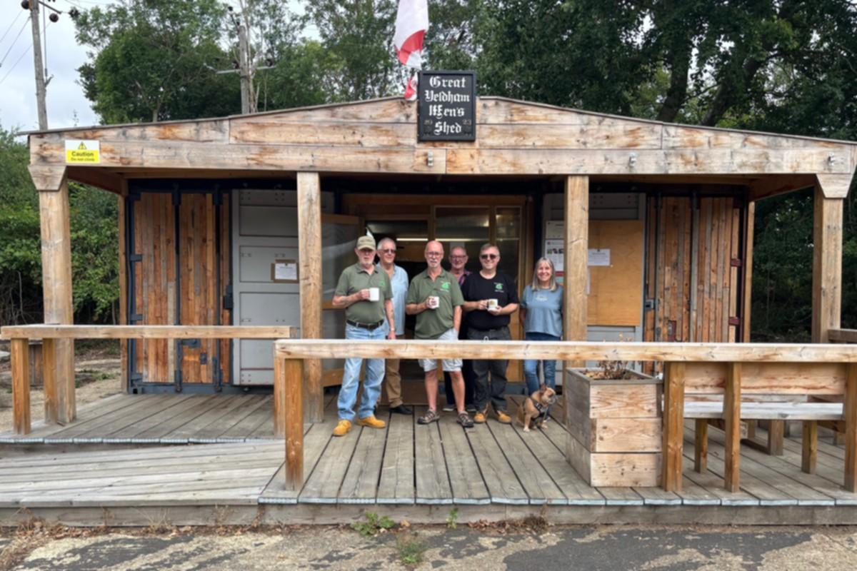 Great Yeldham men's shed - people with cups of tea standing by the shed entrance