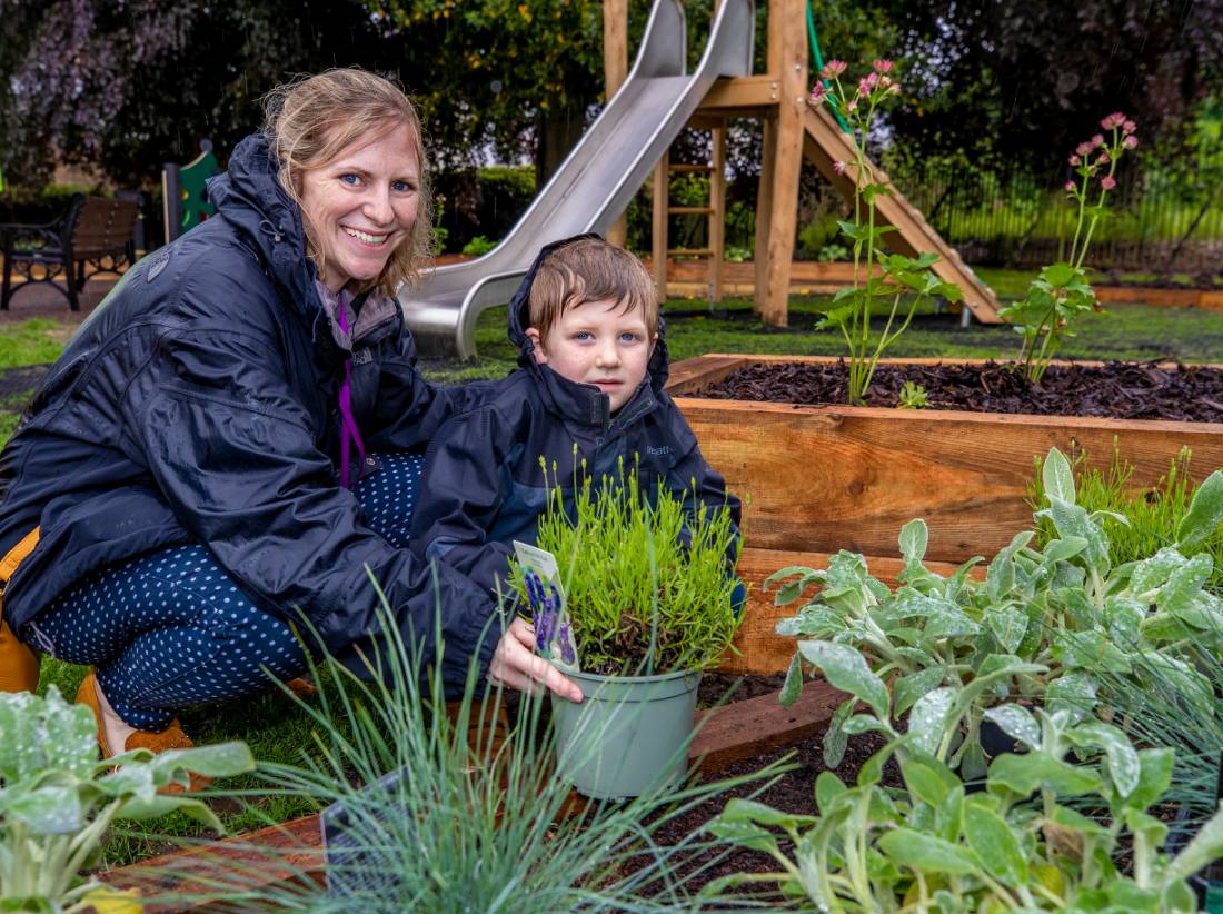 A mother and son planting a tree in a park