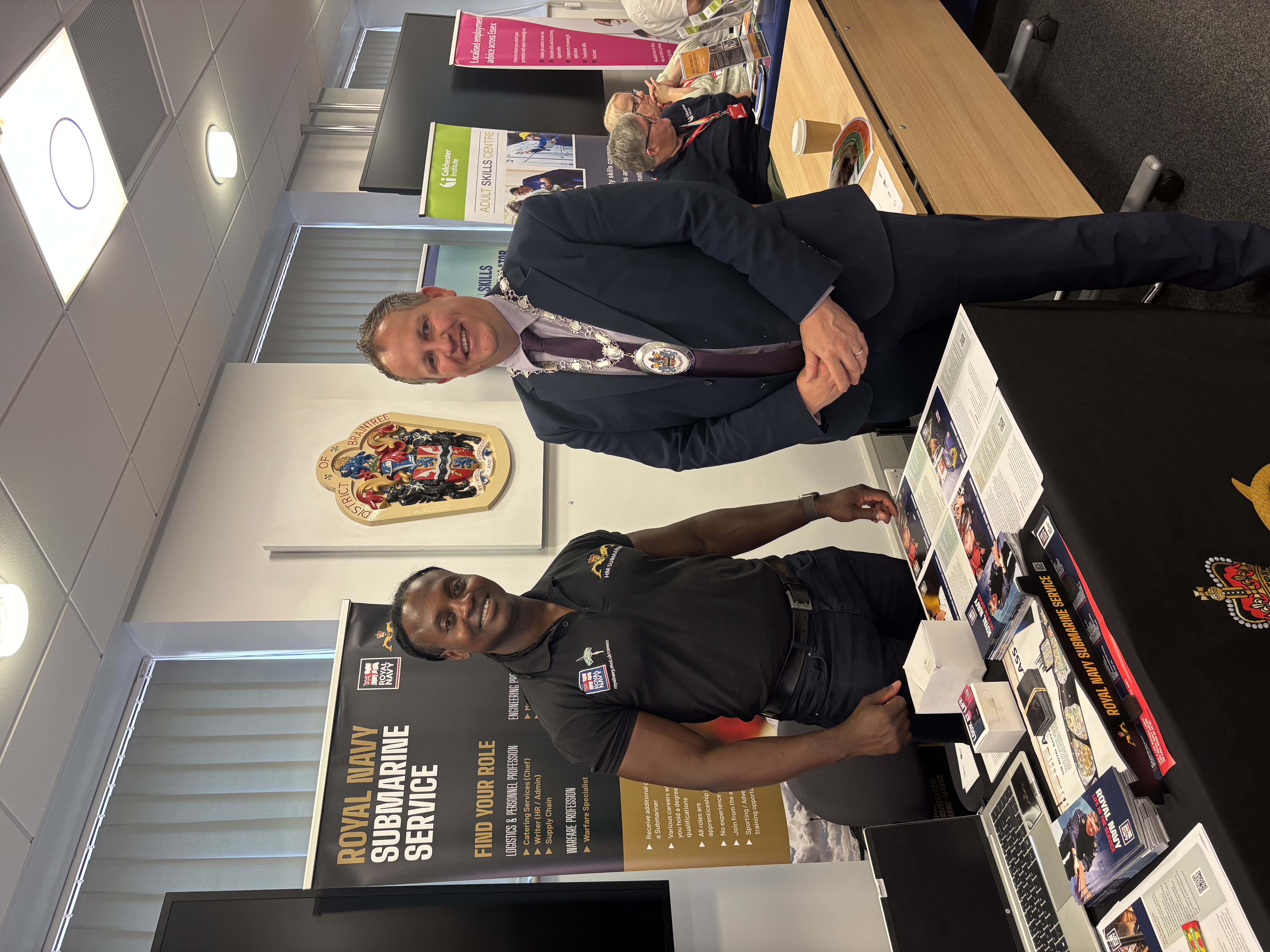 Chairman stands with a royal navy officer looking at the camera.