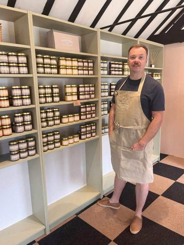 Sticky pickle company shop showing Ian Beaird in front of shelves filled with jars.