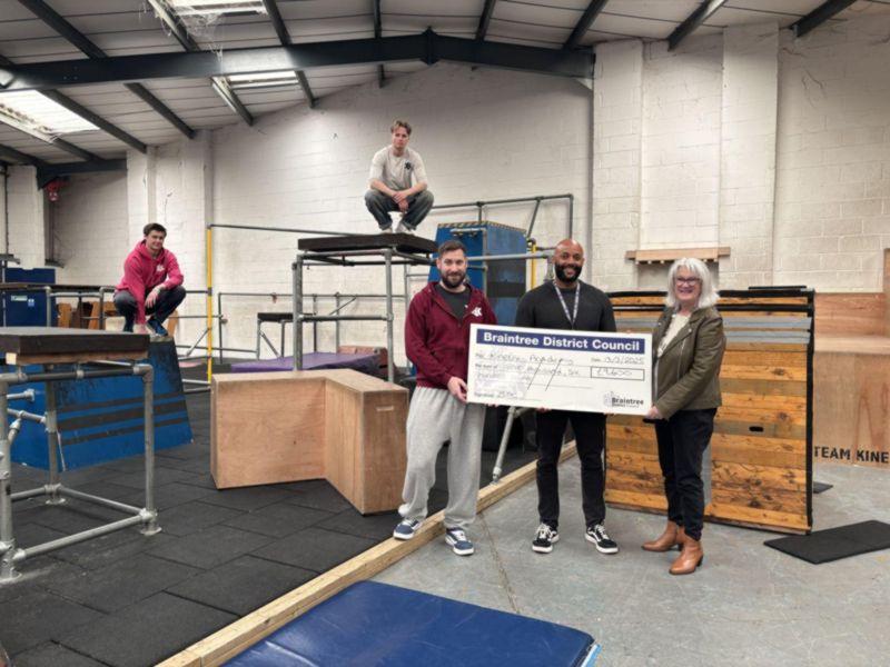 Cost of living grant scheme - Team Kinetix receiving a cheque from councillor