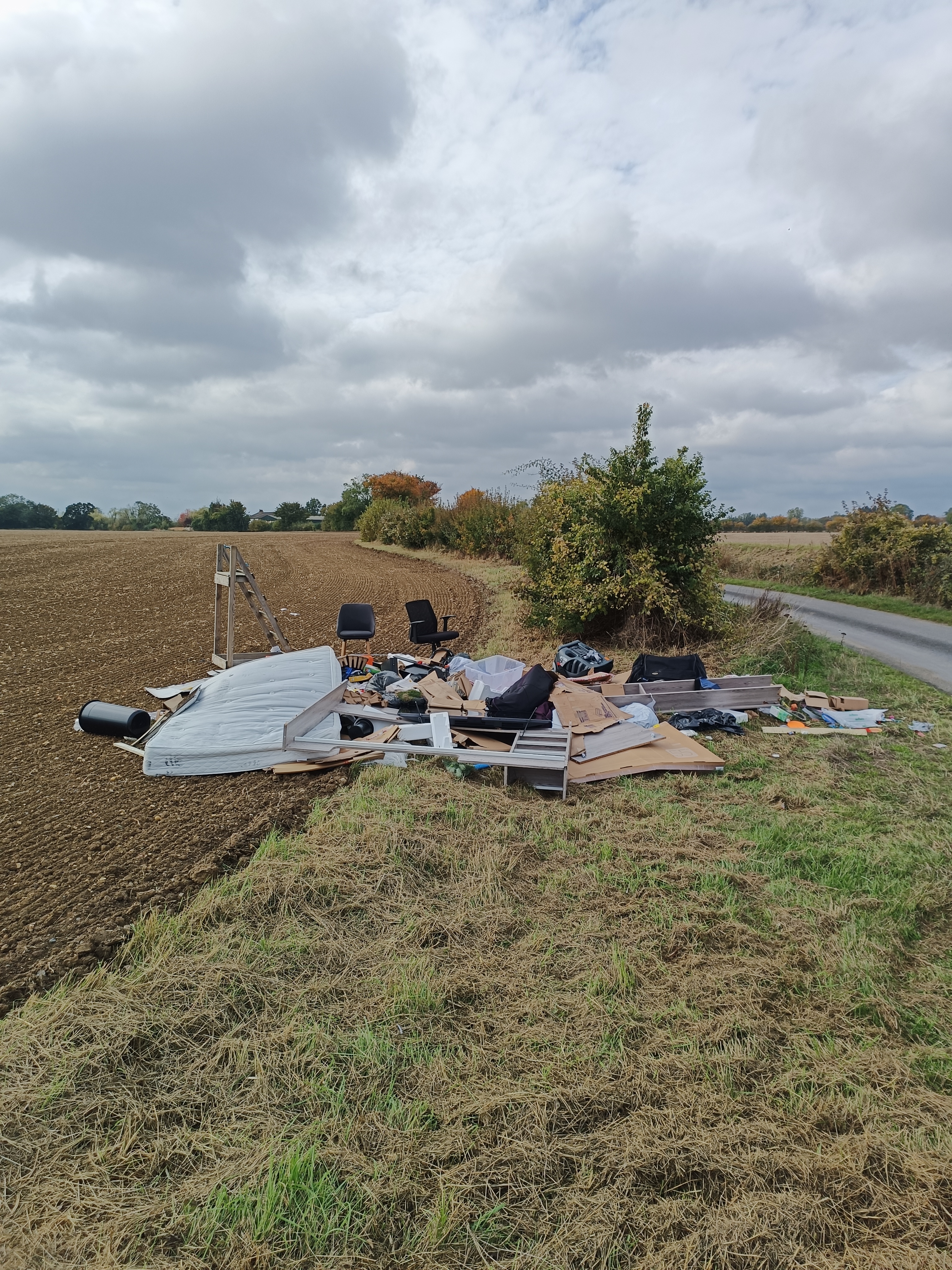 fly-tip showing items such as matrasses, chairs,