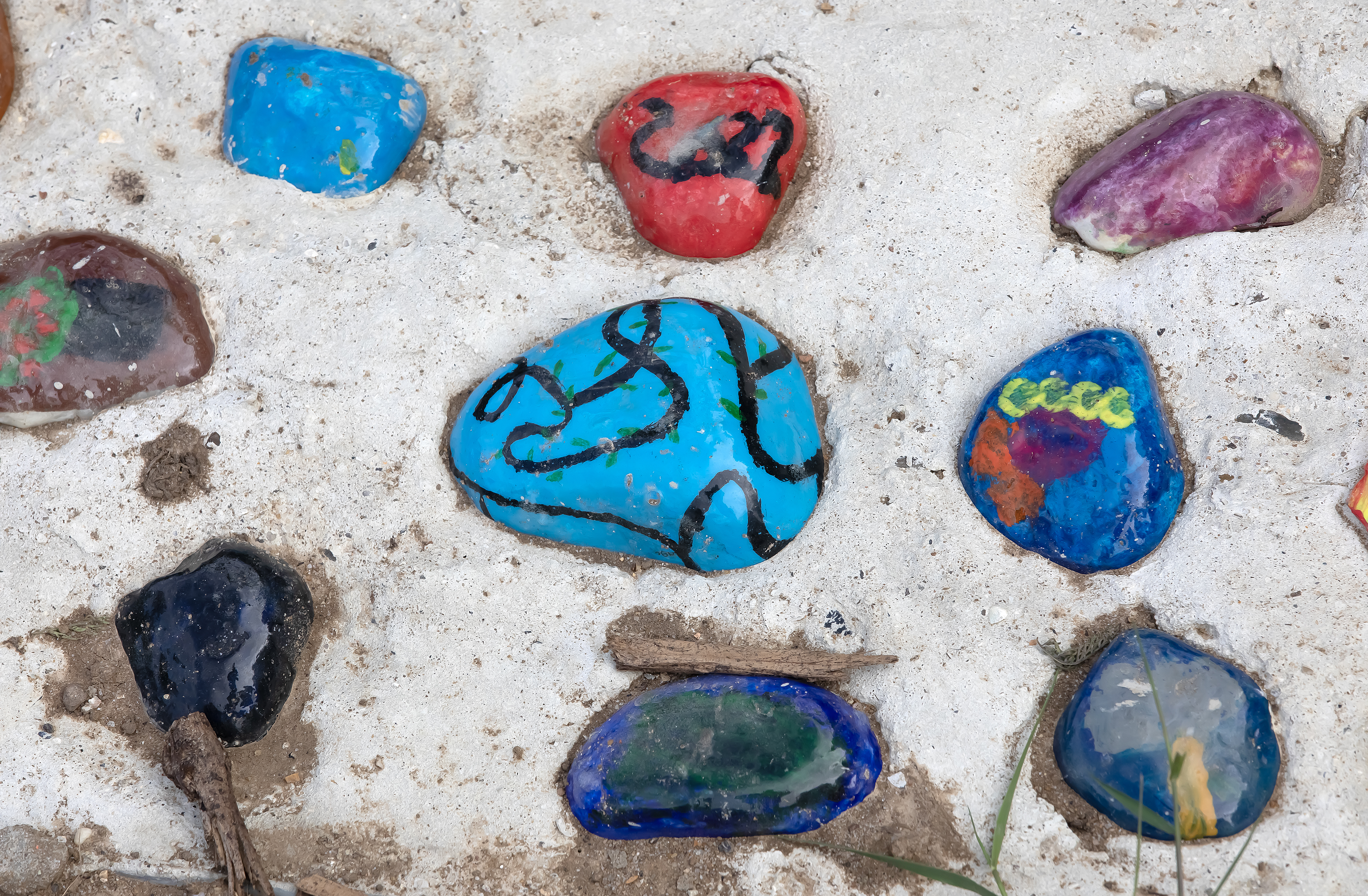 Painted stones set in cement within a garden