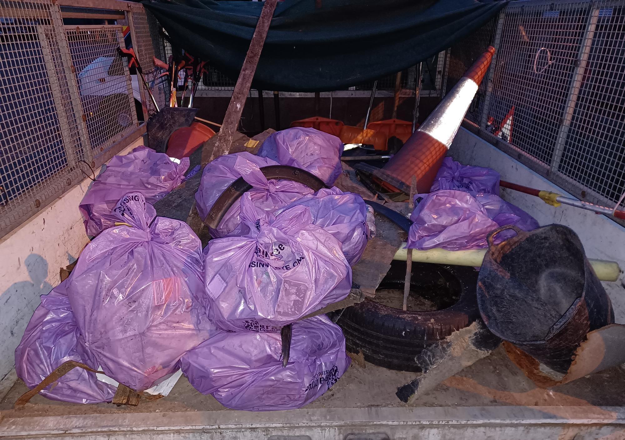 image shows bags of litter and other various items litter picked from the A120 in the back of a BDC low back vehicle