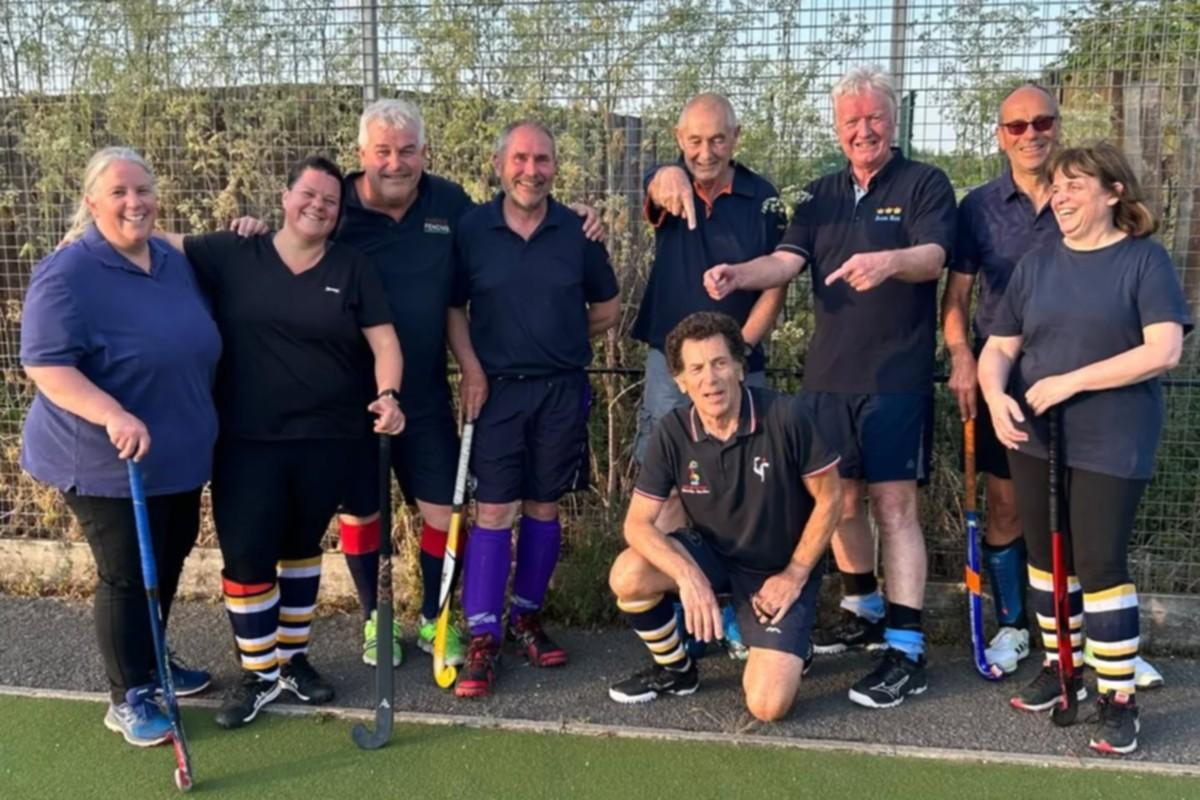 Social hockey group holding hockey sticks